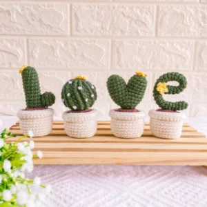 Ensemble décoratif artisanal de quatre cactus en pots réalisés au crochet et formant le mot LOVE